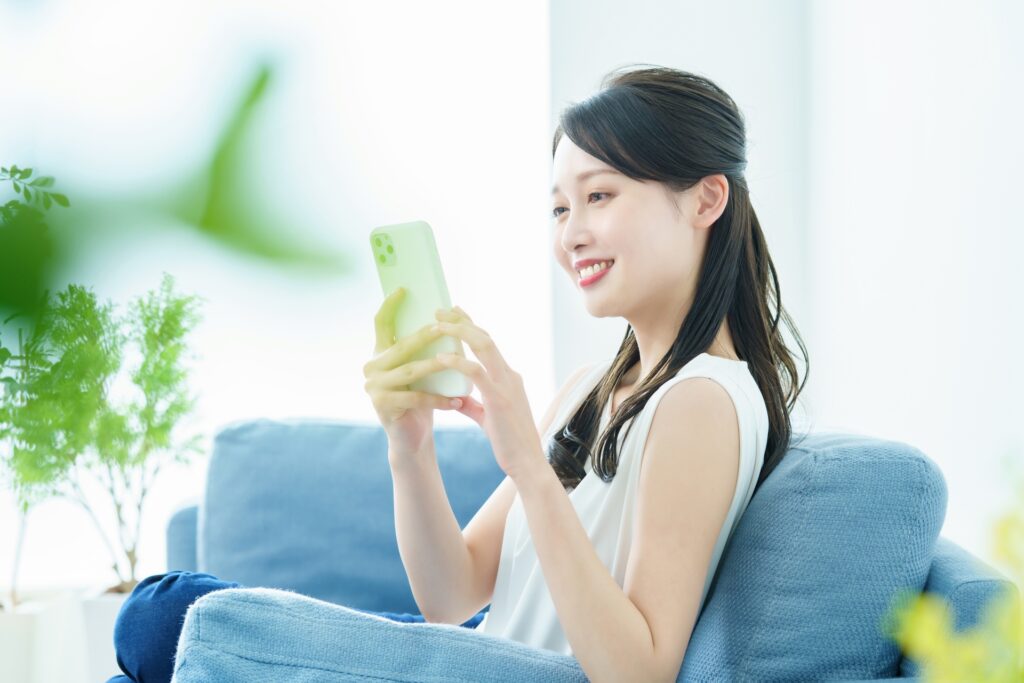 スマホでオンライン予約する女性